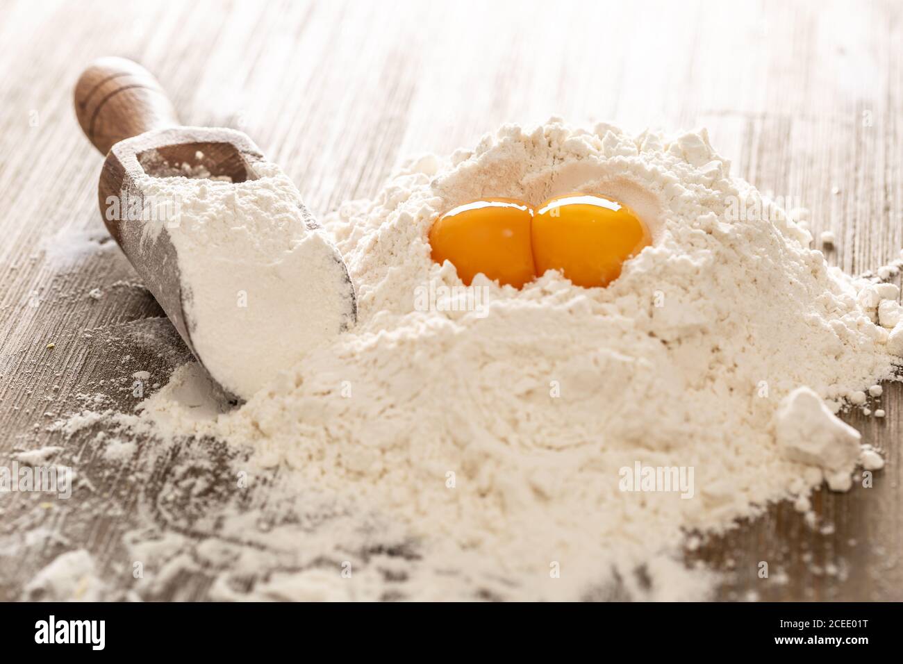 Weizenmehl und Eier auf Backentisch bereit für die Zubereitung von Teigkuchen oder Pasta Stockfoto