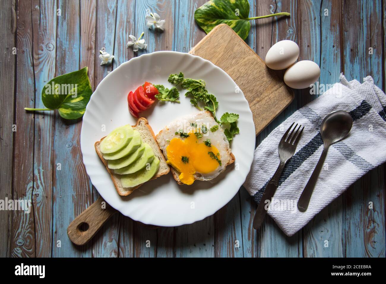 Eier und Brot mit Gewürzen und Avocado Stockfoto