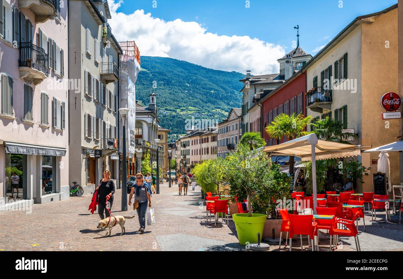 Sion Schweiz , 3. Juli 2020 : Menschen mit ihrem Hund zu Fuß in der Fußgängerzone Grand-Pont-Straße mit leerem Restaurant Terrasse im Sommer 2020 in Sion alt Stockfoto