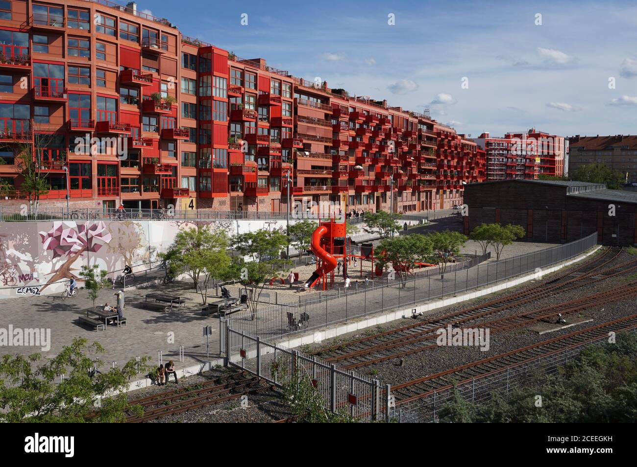 Ein Neubau in Berlin-Schöneberg mit moderner Architektur, mit Spielplatz, Radweg und ehemaligen Bahngleisen davor Stockfoto