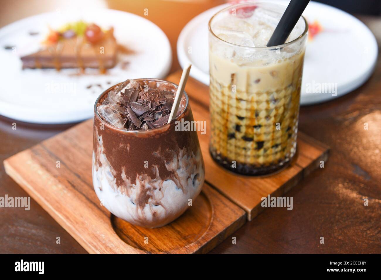 Kakao trinken Schokolade und Bubble Milch Tee oder Taiwan Milch Tee im Glas auf dem Holztisch mit Kuchen Stockfoto