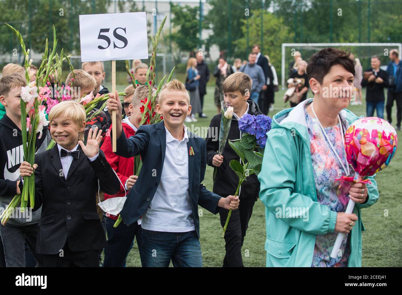 (200901) -- VILNIUS, 1. September 2020 (Xinhua) -- die Schüler nehmen am 1. September 2020 an der Eröffnungsfeier mit Blumensträußen in der Hand Teil, die den Beginn eines neuen Schuljahres am Gymnasium Vilnius Fabijoniskiu in Vilnius, Litauen, markiert. Litauens neues Schuljahr hat normal begonnen, aber Fernunterricht könnte in bestimmten Schulen wieder aufgenommen werden, wenn sie zu COVID-19 Hotspots werden. (Foto von Alfredas Pliadis/Xinhua) Stockfoto