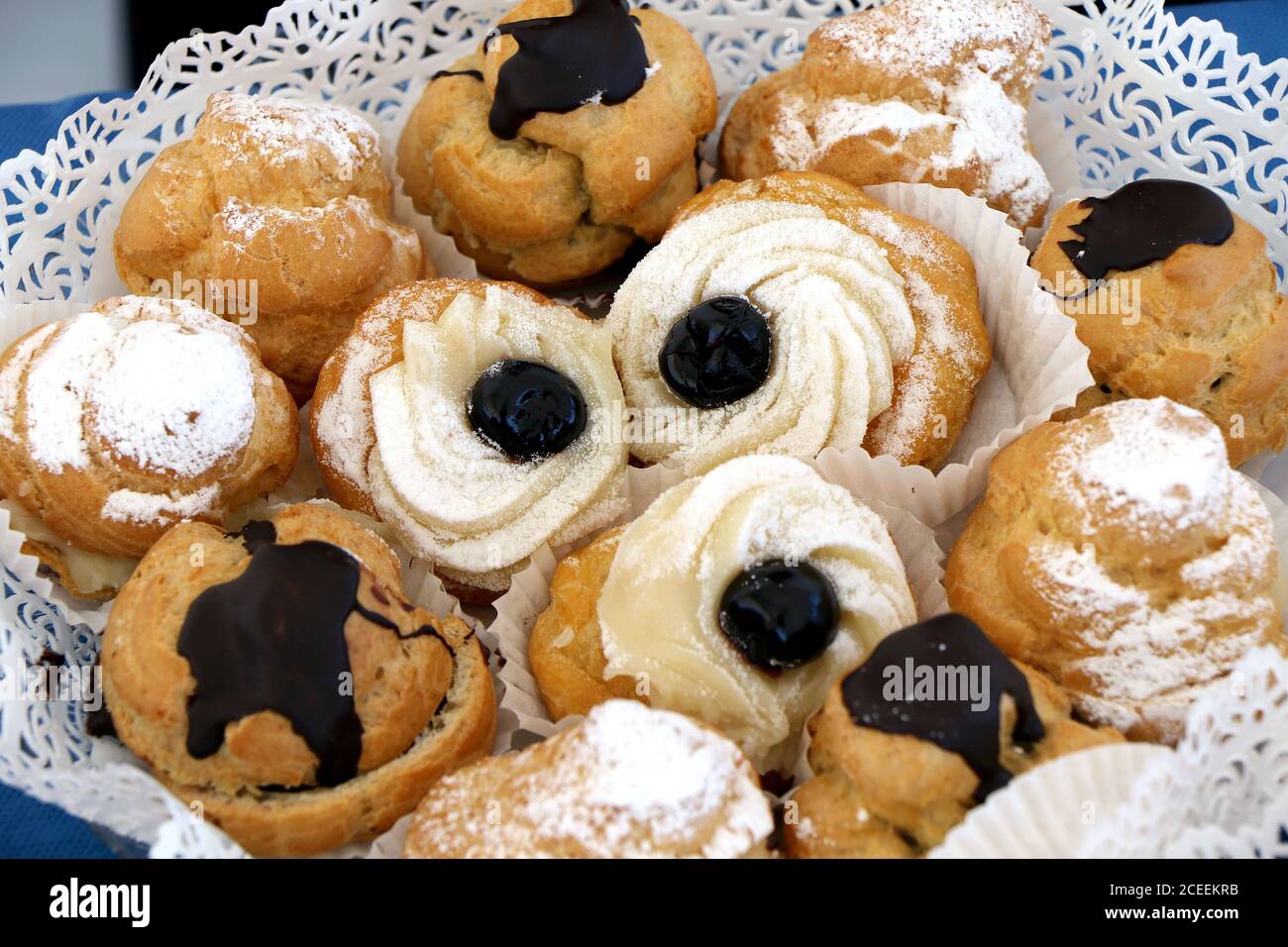 Auswahl an italienischem Gebäck, das Sie genießen können. Zeppole und Cremepuffs Stockfoto