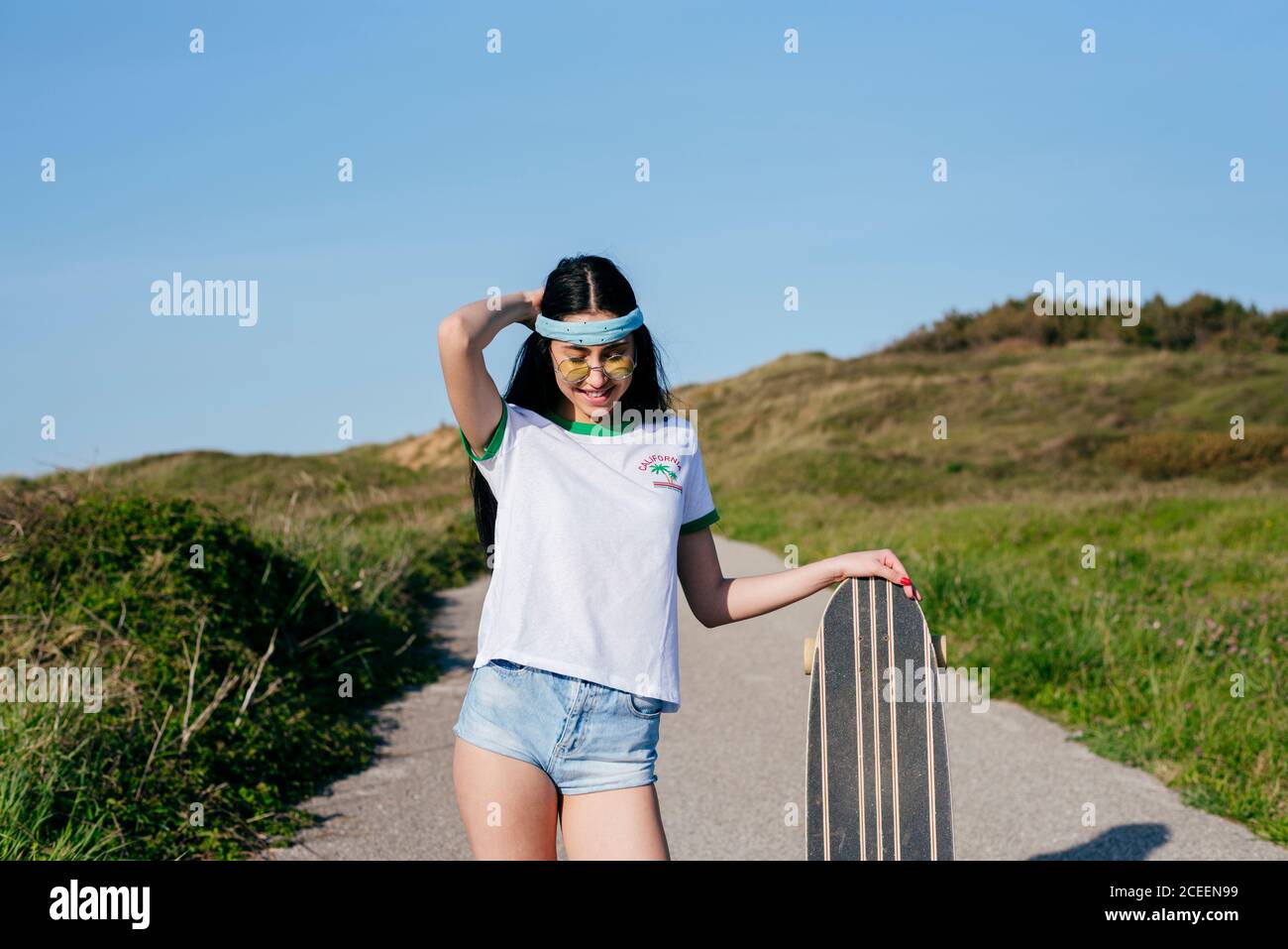 Stilvolle Teenager-Mädchen mit langen Bord im Sommer Stockfoto