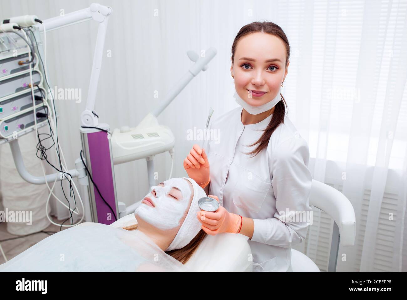 Kosmetologe Anwendung Maske auf das Gesicht des Kunden im Spa-Salon. Wellness-Center. Beruf im Gesundheitswesen Stockfoto