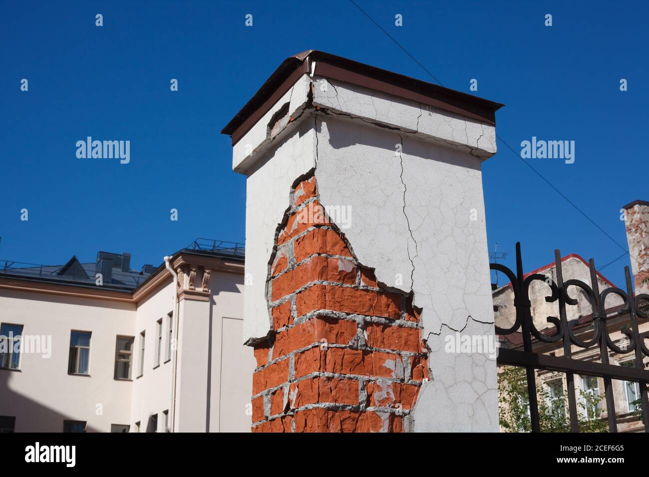 Zerbröckelnde Ziegelsäule des Stadtzauns auf der europäischen Straße Stockfoto