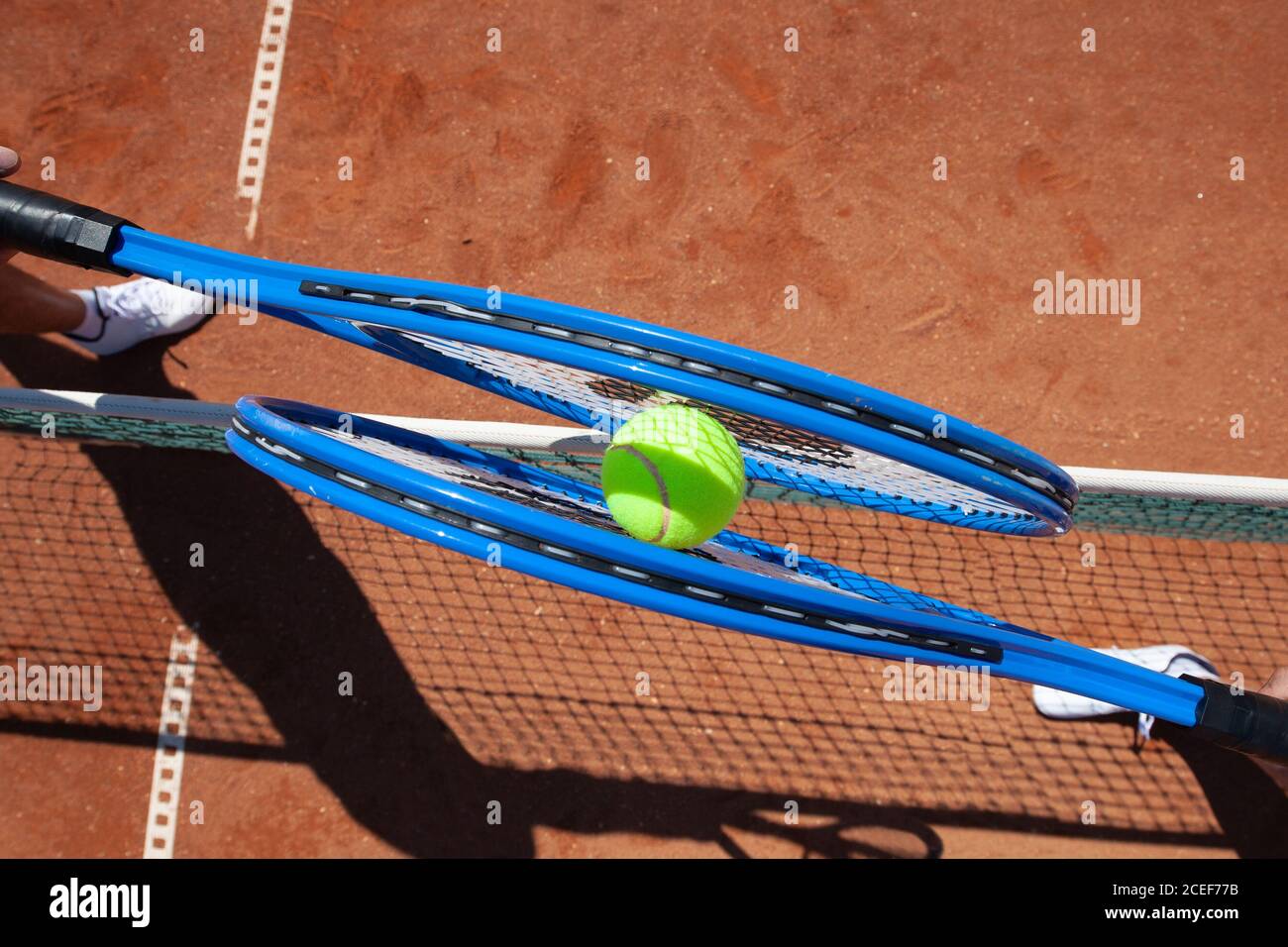 Zwei Tennisspieler schlagen den Ball gleichzeitig Über das Netz Stockfoto