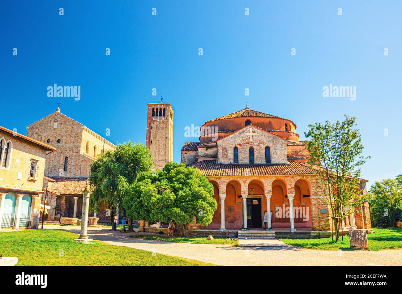 Kirche Santa Fosca Gebäude auf der Insel Torcello, Kathedrale Santa Maria Assunta mit Glockenturm campanile, blauer Himmel Hintergrund. Lagune Von Venedig, Region Venetien, Norditalien. Stockfoto