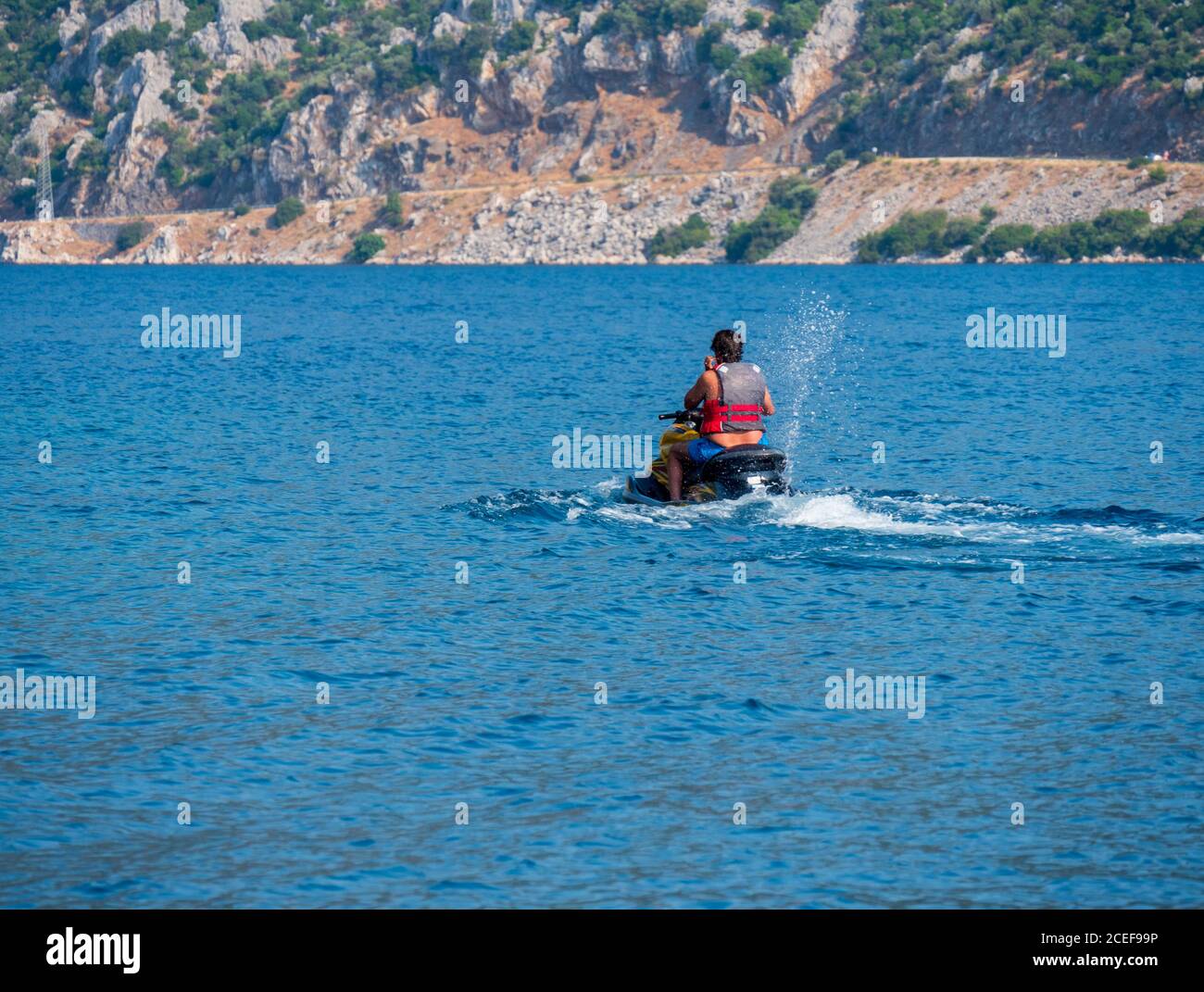 Ein Mann, der auf dem Wasser ein persönliches Wasserfahrzeug reitet Stockfoto