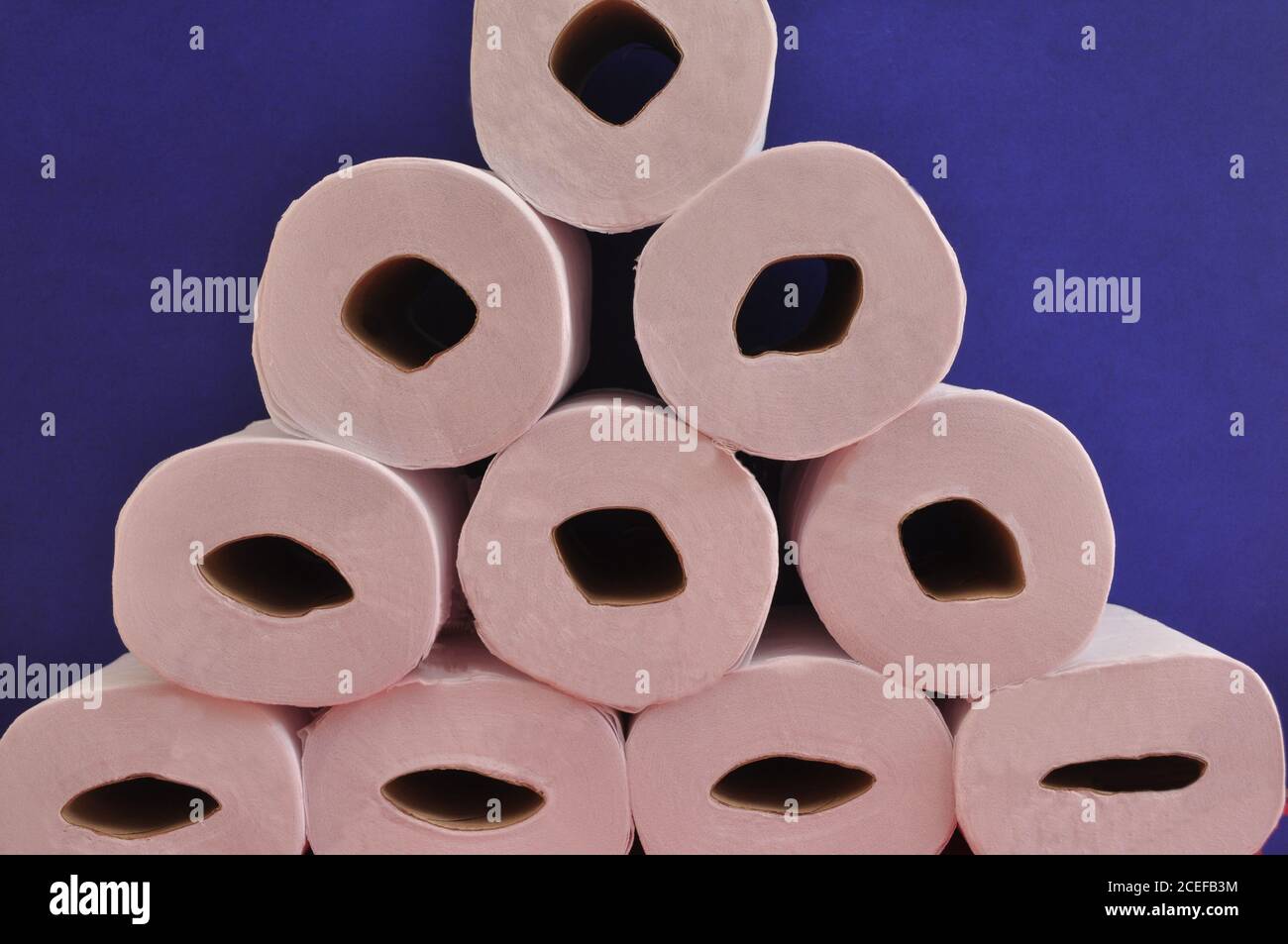 Toilettenpapier. Weiße Toilettenpapier-Pyramide, mehrere Rohre in Seitenansicht mit blauem Hintergrund, Konzeptfoto Stockfoto