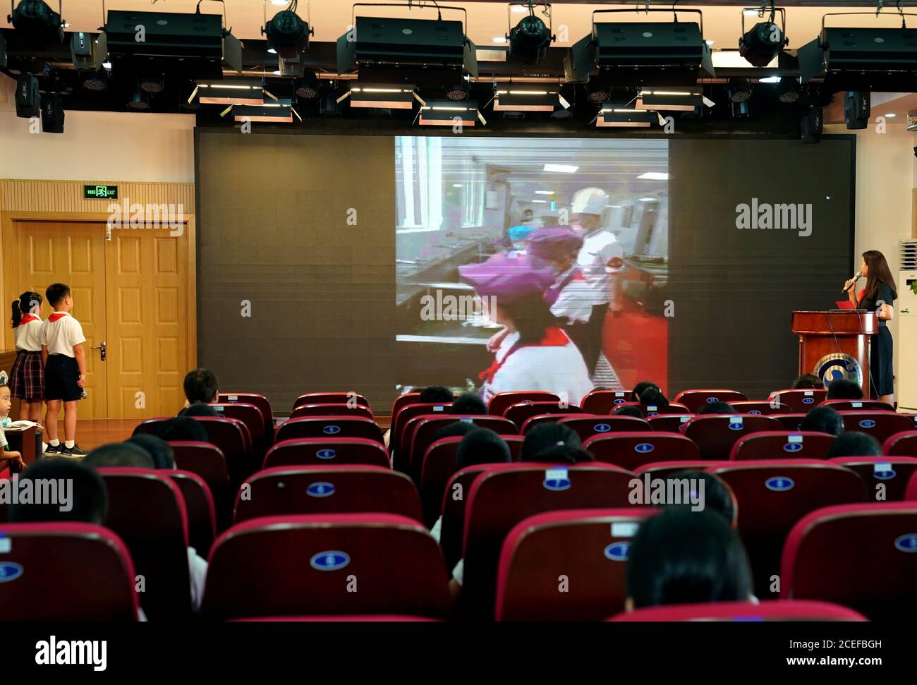 Shanghai. September 2020. Die Schüler beobachten ihre Schulkameraden bei der Hilfe in der Schulküche via Video-Link während der Eröffnungsfeier des neuen Semesters an der Xuhui Experimental Primary School im Xuhui Bezirk im ostchinesischen Shanghai, 1. September 2020. Mit einer Mischung aus Nerven und Aufregung starteten viele Schüler in China am Dienstag ein neues Schuljahr. "Sparsamkeit üben und Abfall reduzieren" wurde als Thema der ersten Unterrichtsstunde im neuen Semester an vielen Schulen in Shanghai gesetzt. Quelle: Liu Ying/Xinhua/Alamy Live News Stockfoto