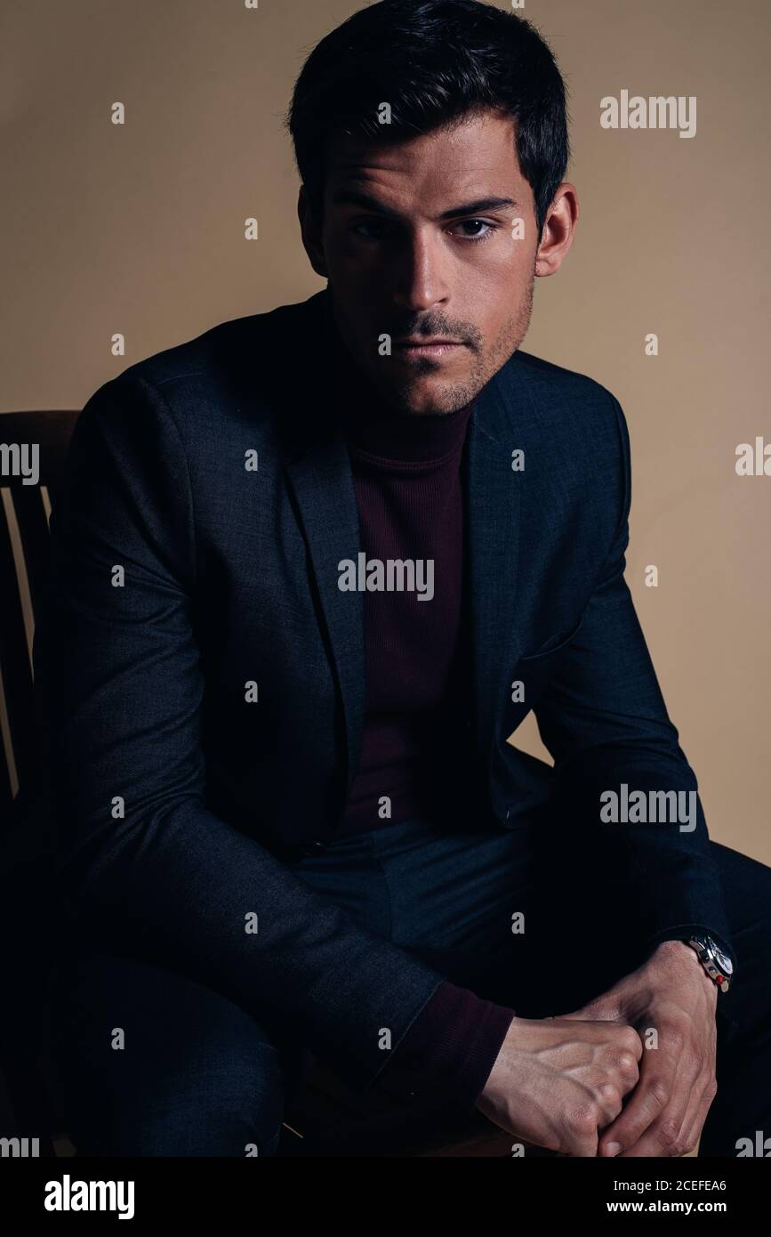 Junger Geschäftsmann in einem Studio, der in einem Stuhl sitzt Stockfoto