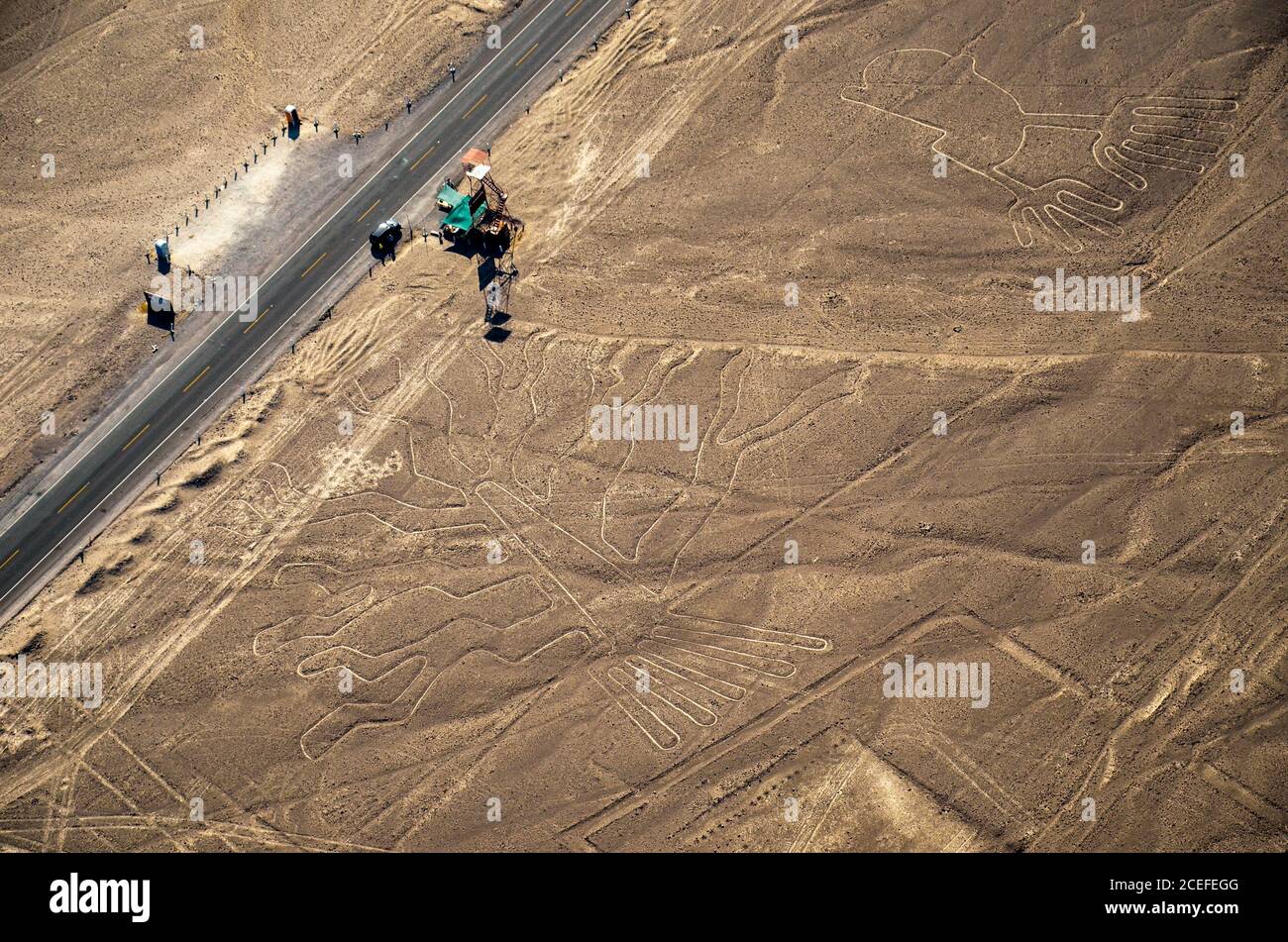 Luftaufnahme der Baum- und Nazca-Linien und der panamerikanischen Autobahn in Peru. Fahrzeug parkt am Aussichtsturm neben mysteriösen Linien. Stockfoto