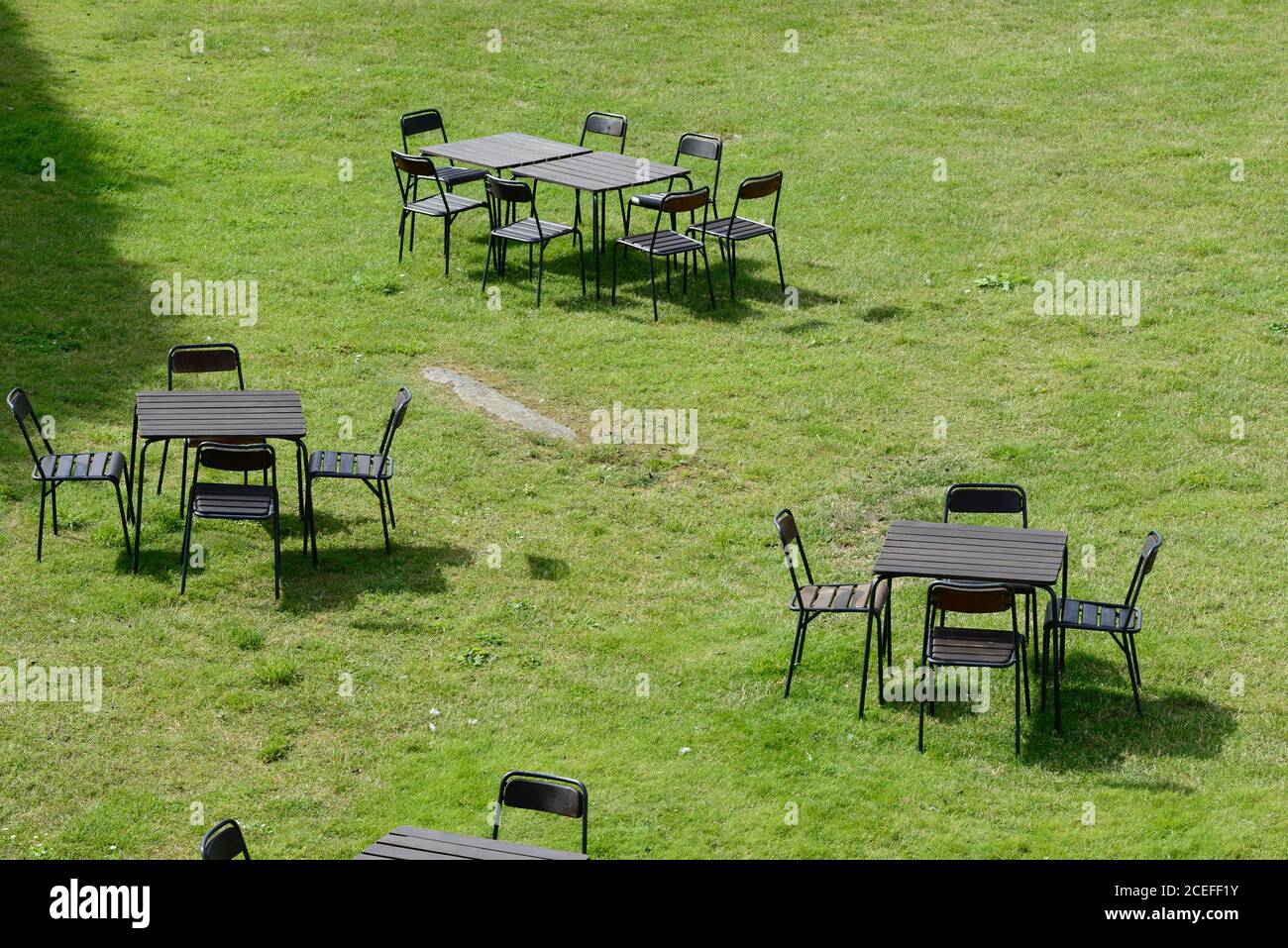 Stühle und Tische im Freien auf einer grünen Wiese Stockfoto