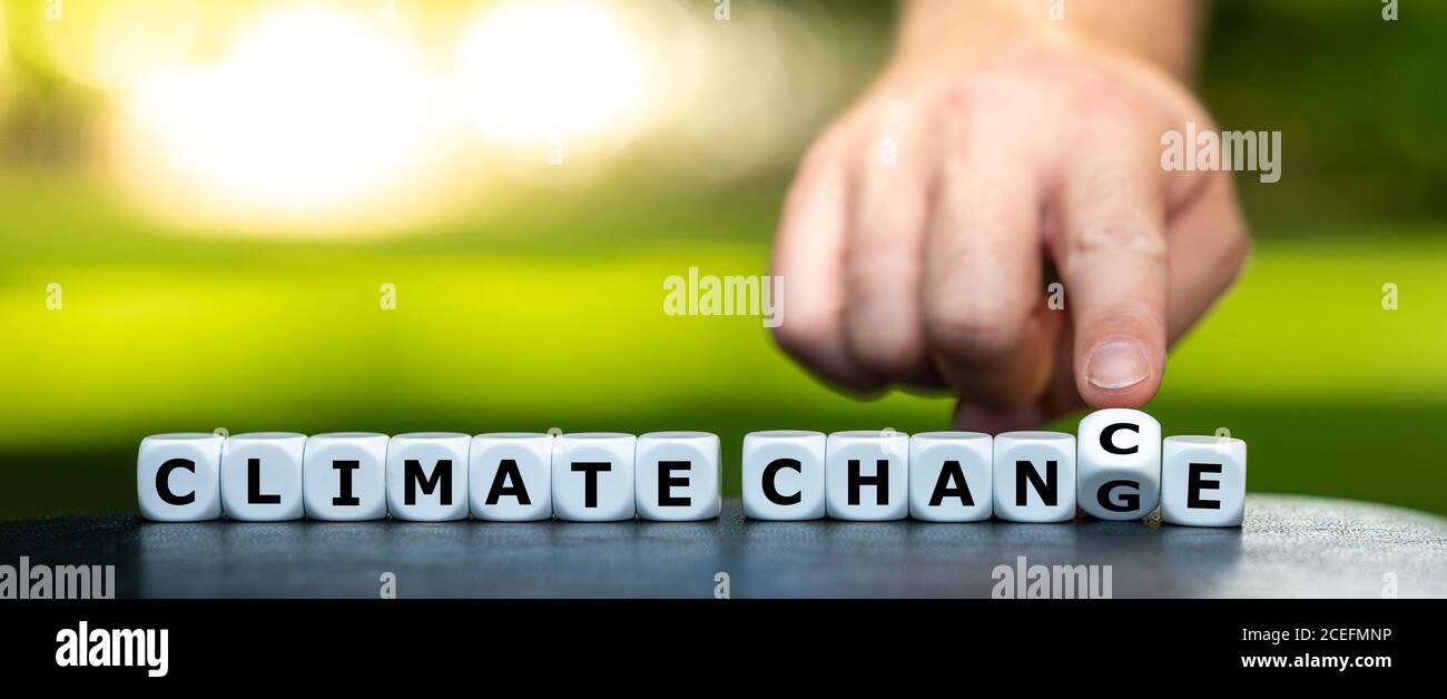 Hand dreht Würfel und ändert den Ausdruck "Klimawandel" in "Klimachance". Stockfoto