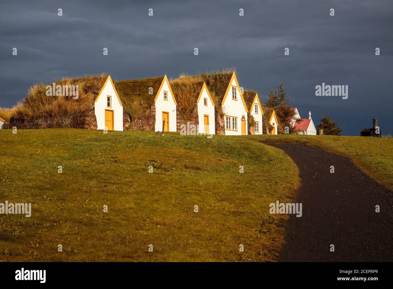 Es gibt ein paar Häuser mit Strohhäppchen, die Schlange stehen Feld in fröhlichen Tag in Island Stockfoto