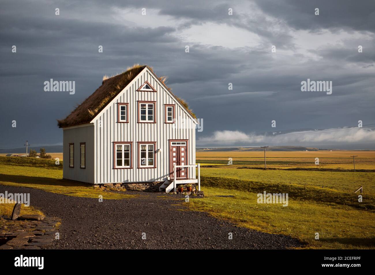 Landhaus mit Strohdach steht zwischen riesigen Champ in fröhlich Tag in Island Stockfoto