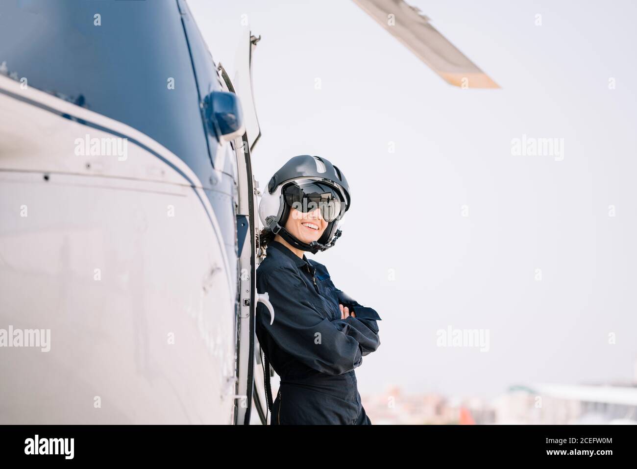 Pilot Mädchen posiert mit ihrem Hubschrauber und Helm Stockfoto