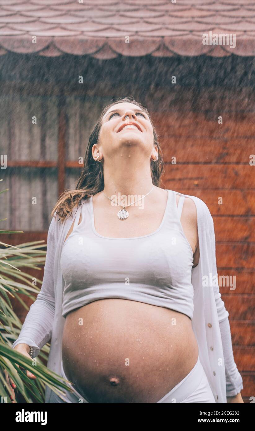 Schöne Schwangerin posiert im Regen. Stockfoto