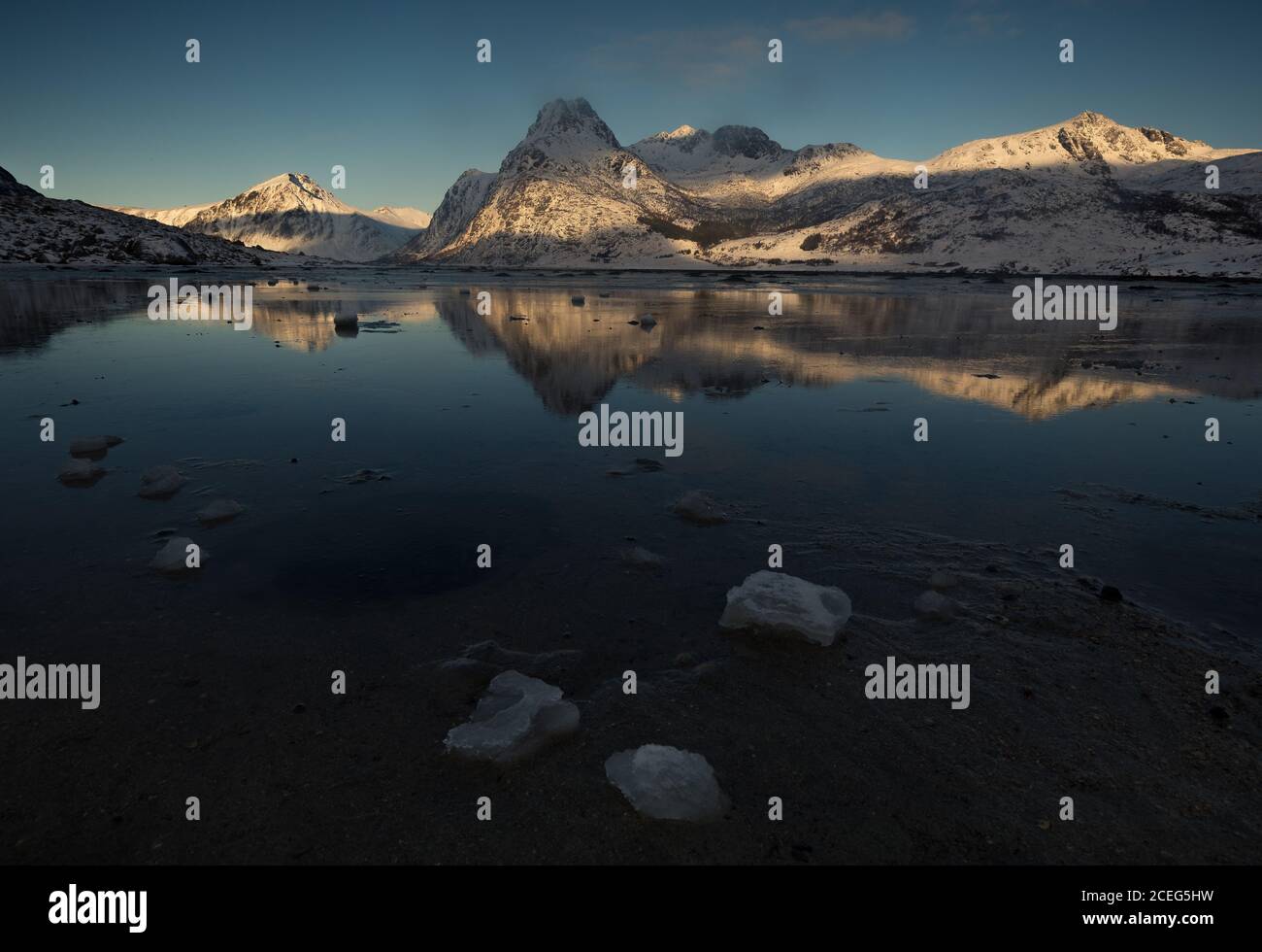 Winzige Eisstücke, die auf der Oberfläche des kalten Meeres in der Nähe der Bergküste der Lofoten, Norwegen fließen. Stockfoto