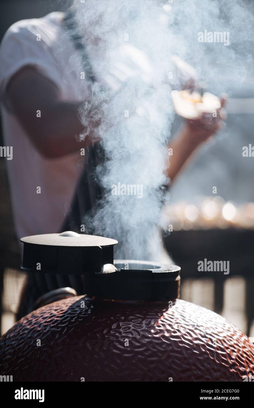 Nahaufnahme des Dampfes, der aus dem geöffneten Durchgang kommt, der die Luft belüftet Innen von Stahl Grill mit Mann Kochen auf Hintergrund Stockfoto