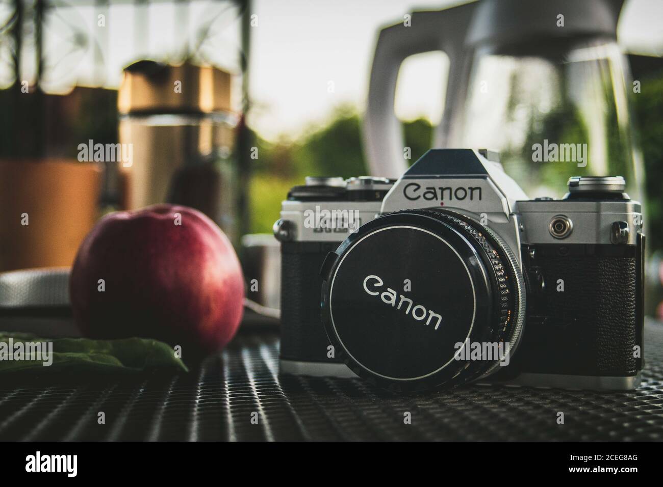 LAGE, 21. Jul 2020: Canon AE-1 Kamera neben einem Apfel und einigen Erbsen Stockfoto