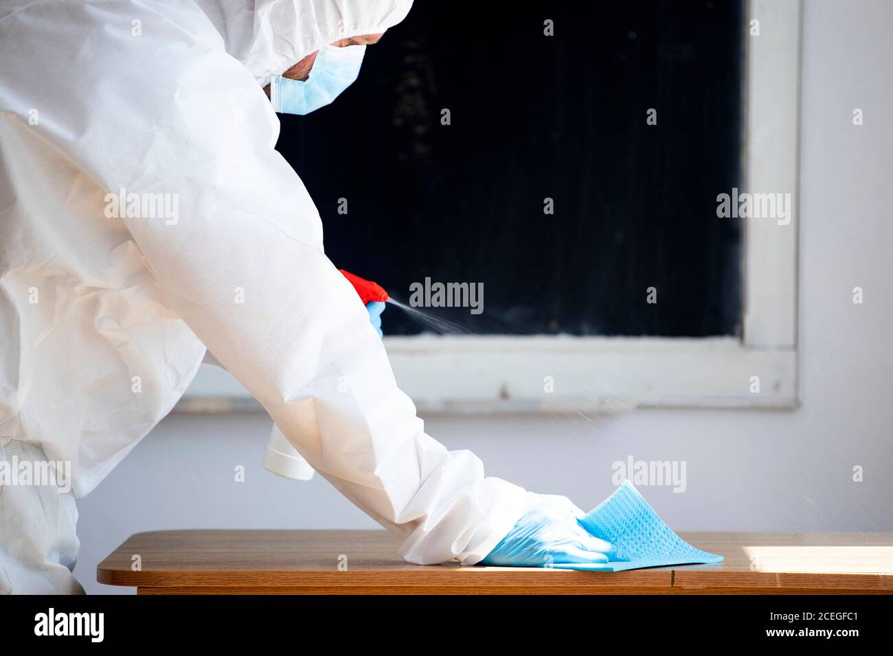 Arbeiter sprüht Desinfektionsmittel im Rahmen von Präventivmaßnahmen gegen die Ausbreitung des COVID-19, des neuartigen Coronavirus in Schulen. Vorbereitung auf das neue Stockfoto