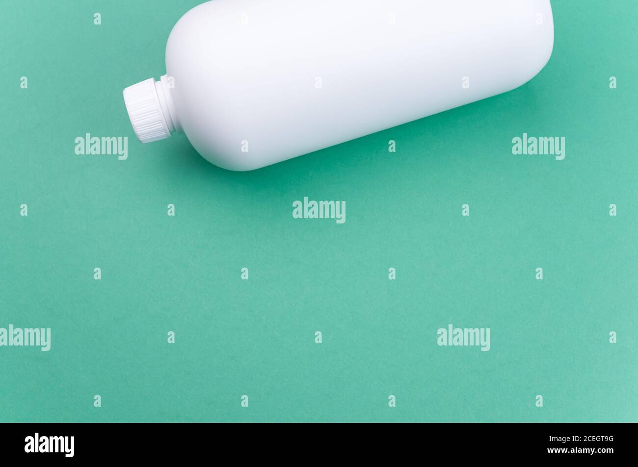 Nahaufnahme eines weißen Plastikbehälters auf einem grünen Oberfläche Stockfoto