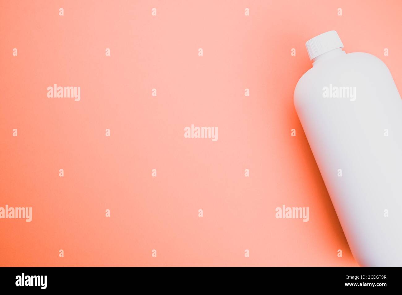 Nahaufnahme eines weißen Plastikbehälters auf einer Orange Oberfläche Stockfoto