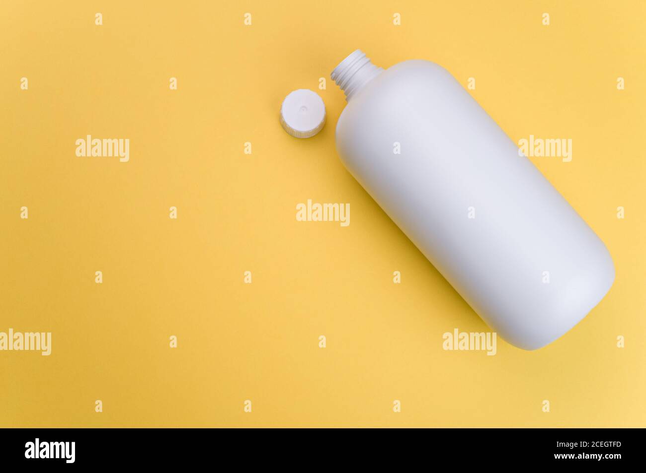 Nahaufnahme eines weißen Kunststoffbehälters mit offenem Deckel auf einer gelben Oberfläche Stockfoto