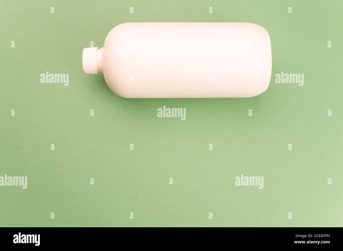 Nahaufnahme eines weißen Plastikbehälters auf einem grünen Oberfläche Stockfoto