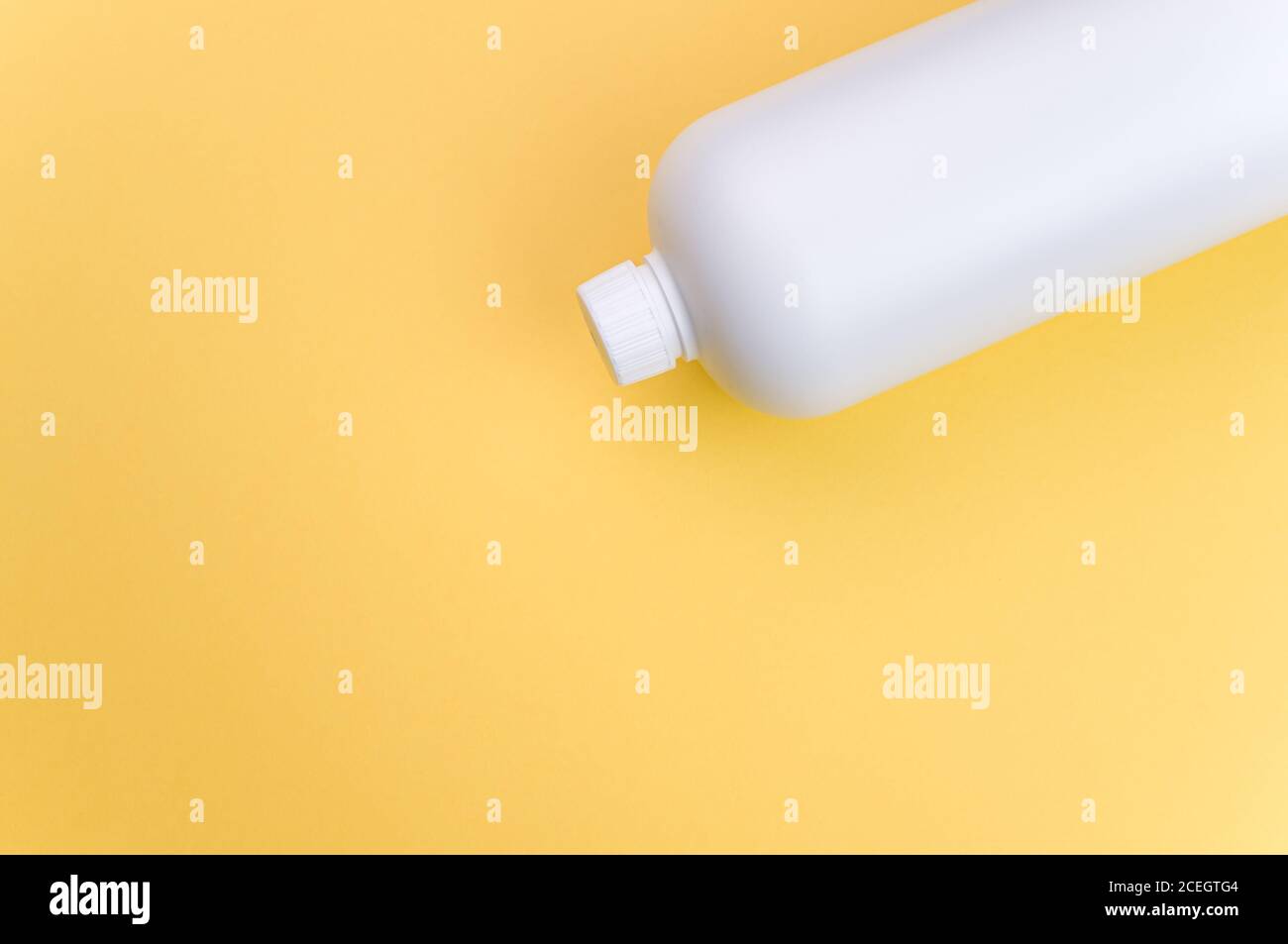 Nahaufnahme eines weißen Plastikbehälters auf einem gelben Oberfläche Stockfoto