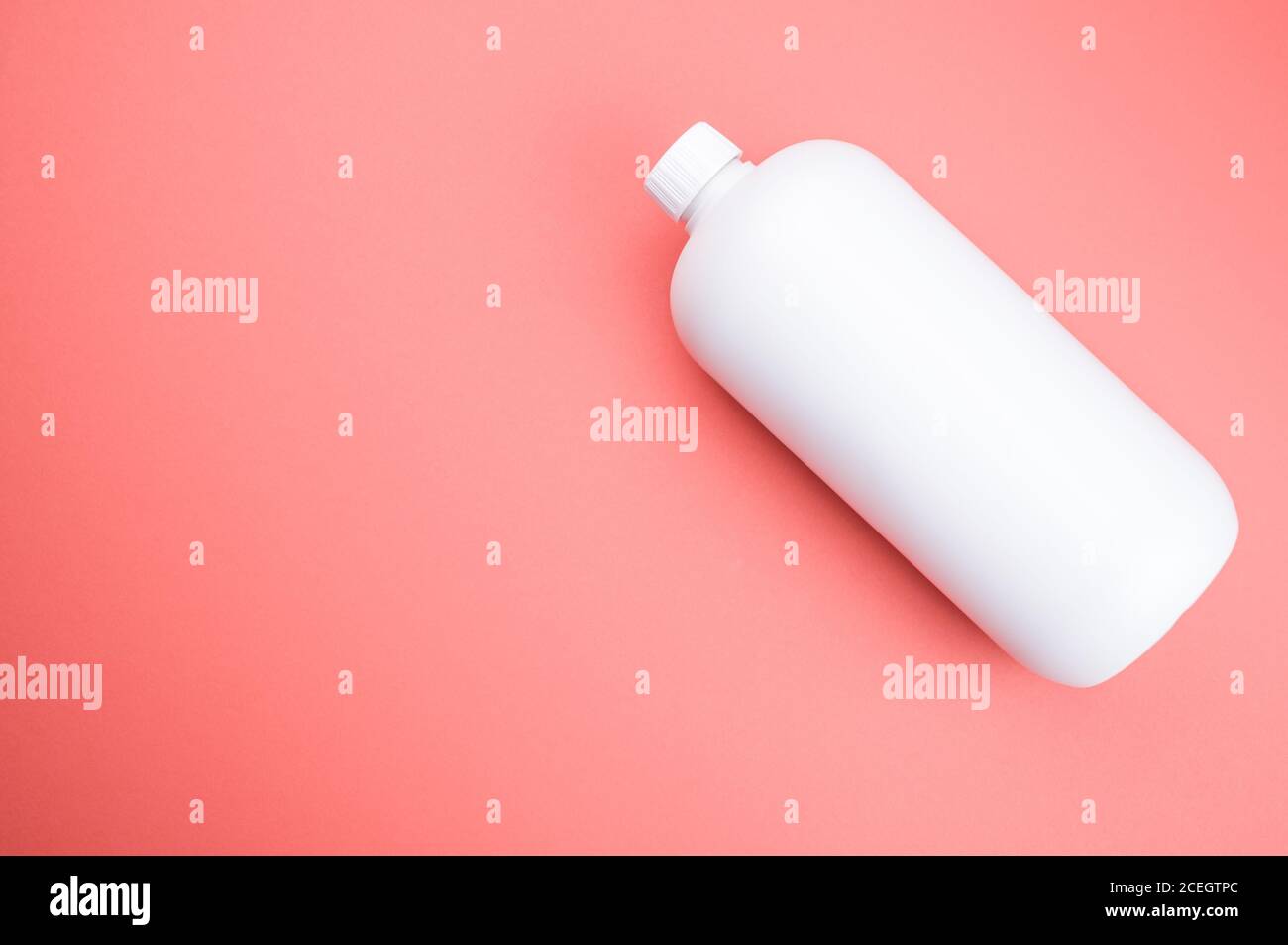 Nahaufnahme eines weißen Plastikbehälters auf einem rosa Oberfläche Stockfoto