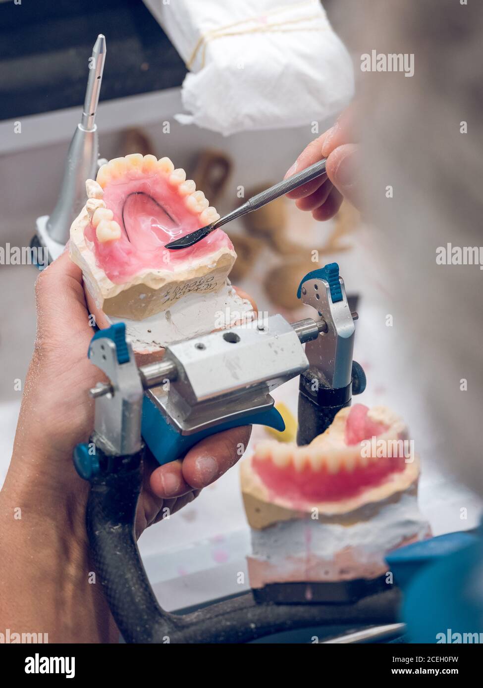 Crop Zahntechniker mit Werkzeug, um flüssiges Material auf Zahnfleisch der  Prothese während der Arbeit im Labor gelten Stockfotografie - Alamy