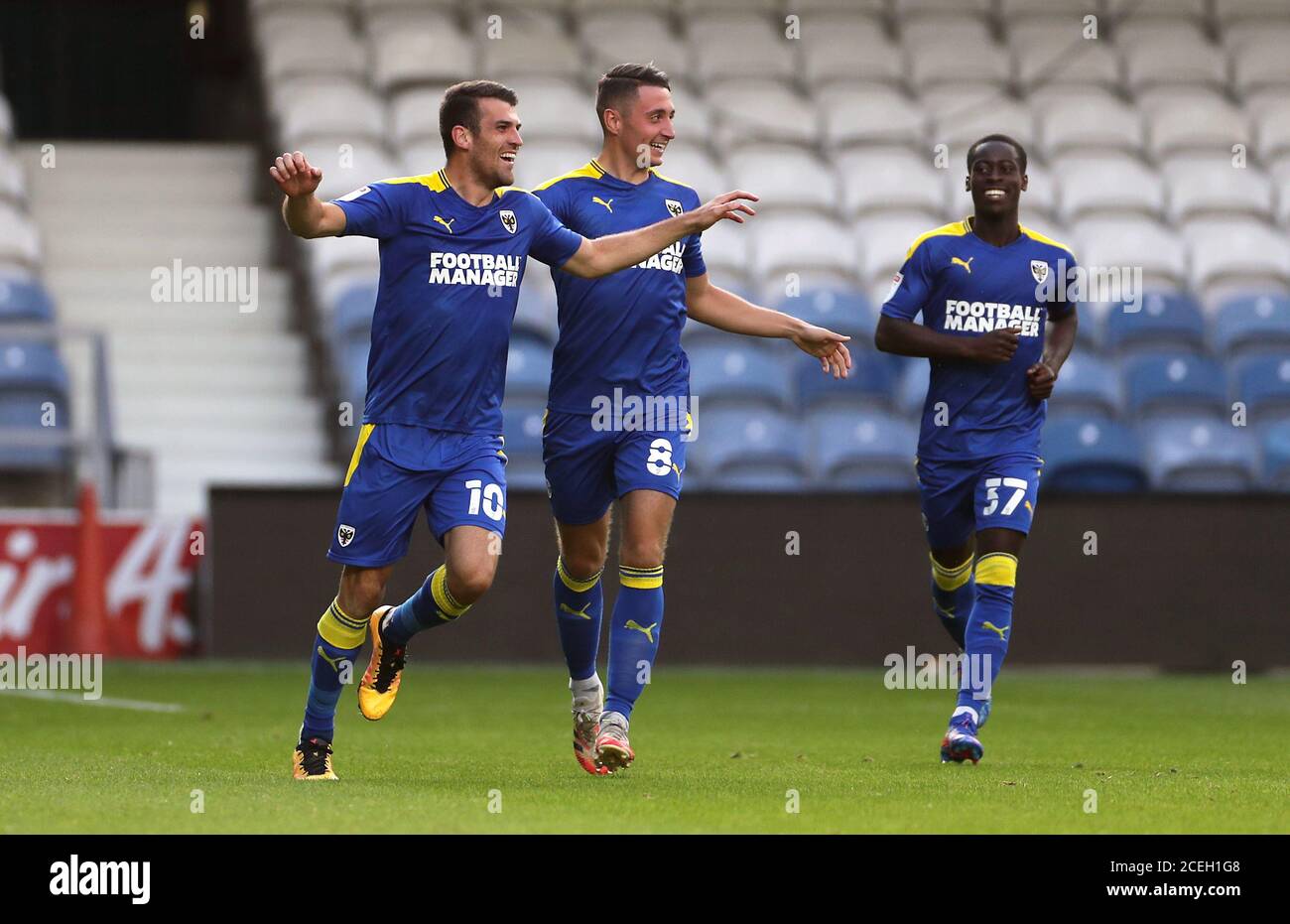 AFC Wimbledon's Adam Roscrow (links) feiert Scoring seiner Mannschaft das erste Tor des Spiels mit Teamkollegen während der EFL Trophy, Southern Group G Spiel im Kiyan Prince Foundation Stadium, London. Stockfoto