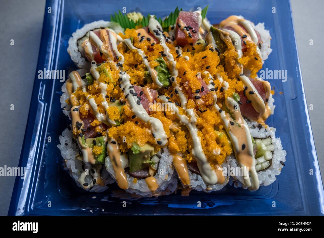 Plastikbehälter voller frisch zubereiteter hawaiiianischer Sushi-Rolle Der Supermarkt mit Wasabi Ingwer und Sojasauce serviert Die Seite Stockfoto
