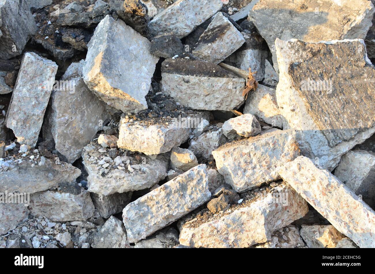 Zerbrochene Asphaltstücke auf einer Baustelle. Recycling und Wiederverwendung zerkleinerten Betonschutt, Asphalt, Baumaterial, Blöcke. Zerkleinert сoncrete Bac Stockfoto