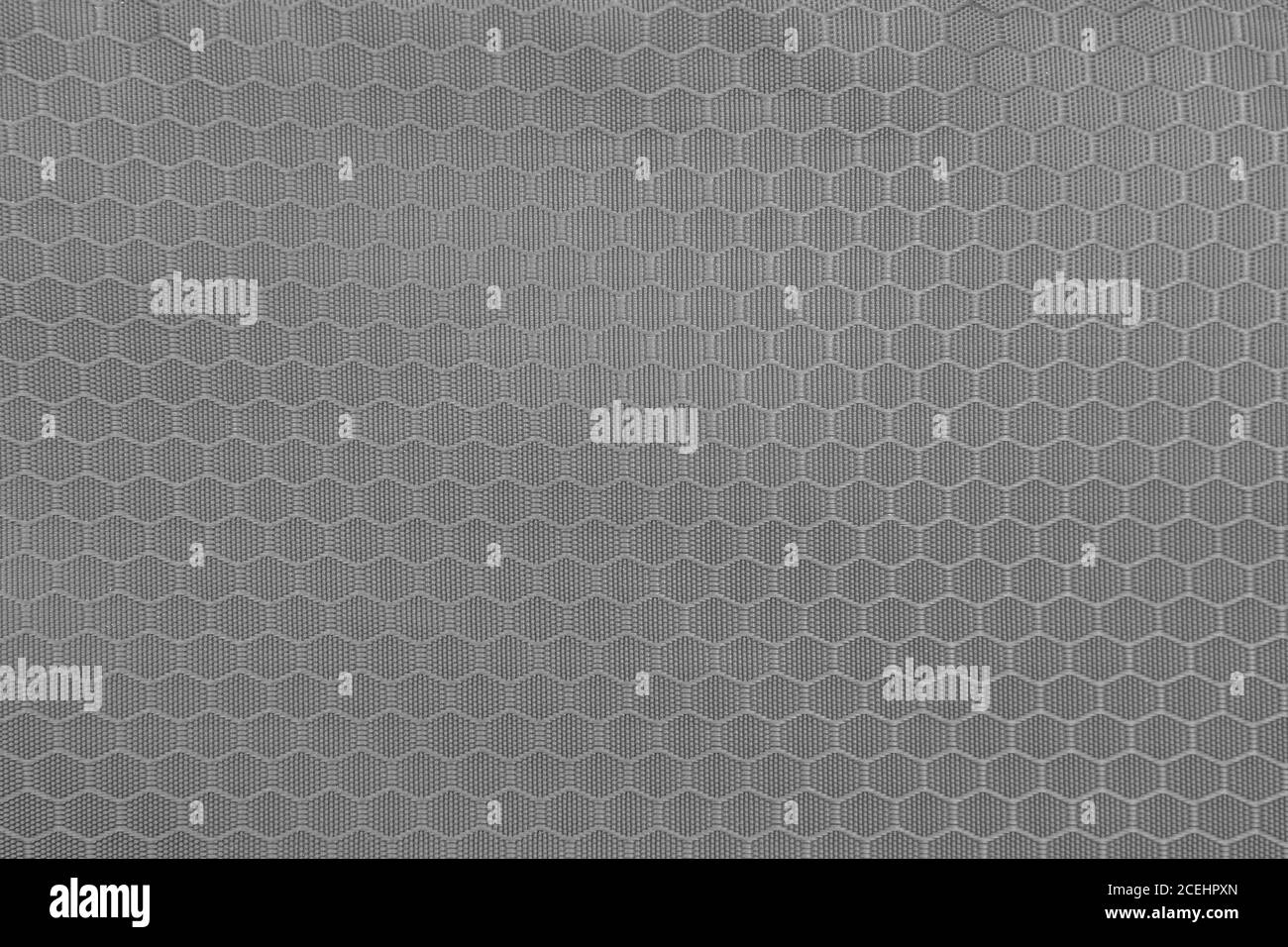 Graue Wabenhintergrund Textur. Textur Hintergrund aus Polyester-Gewebe. Muster aus Kunststoff-Webgewebe Stockfoto