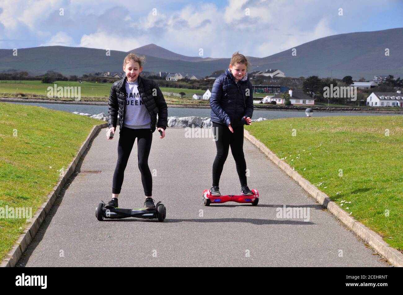 Jugendliche genießen ihre Hoverboards in der Frühlingssonne auf der Marina Wellenbrecher von Dingle Hafen..Dingle Halbinsel, Grafschaft Kerry, Irland. Stockfoto