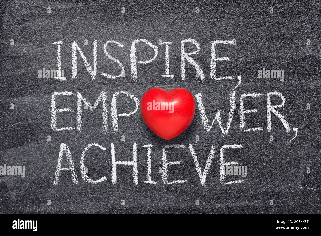 Inspirieren, stärken, erreichen Worte auf Kreidetafel mit rotem Herz Symbol geschrieben Stockfoto