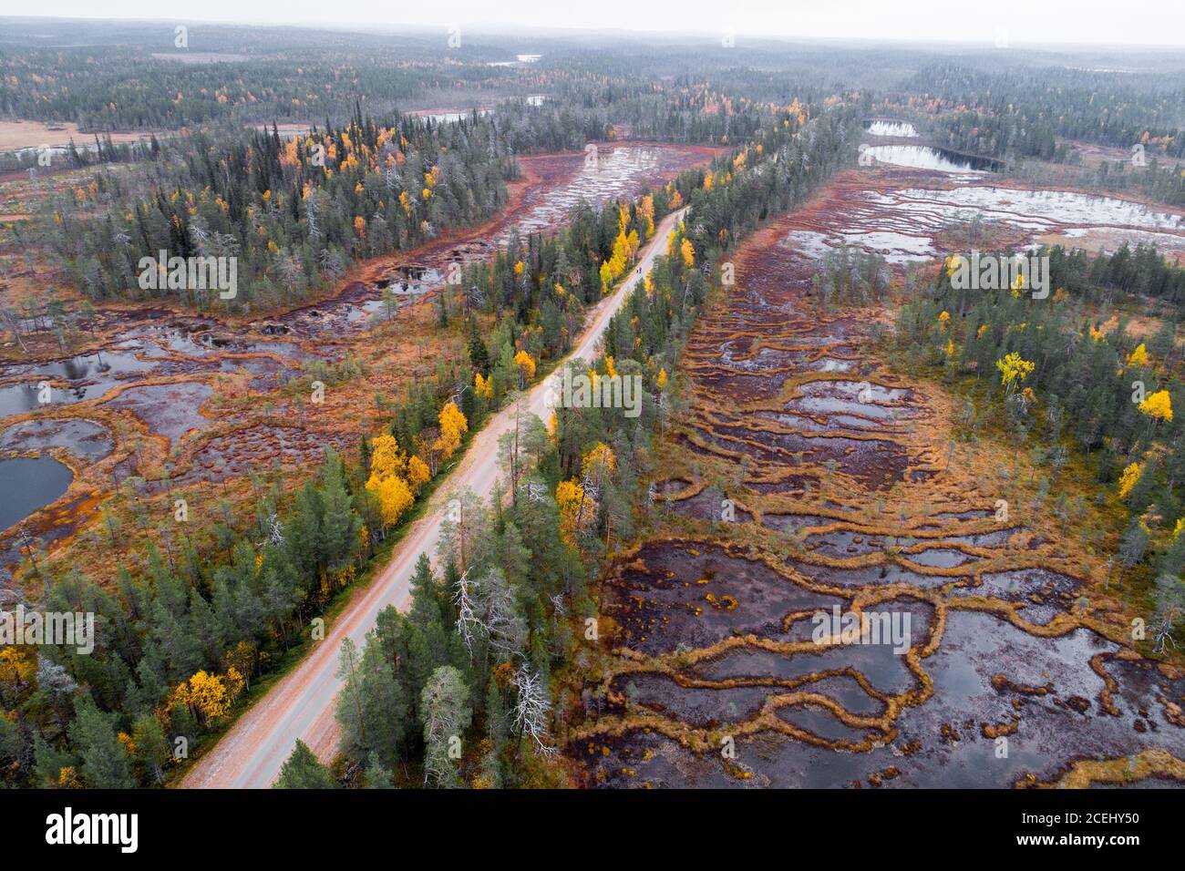 Eine Luftaufnahme einer Straße durch eine einzigartige Aapa Mires in Nordfinnland während Herbstlaub. Stockfoto