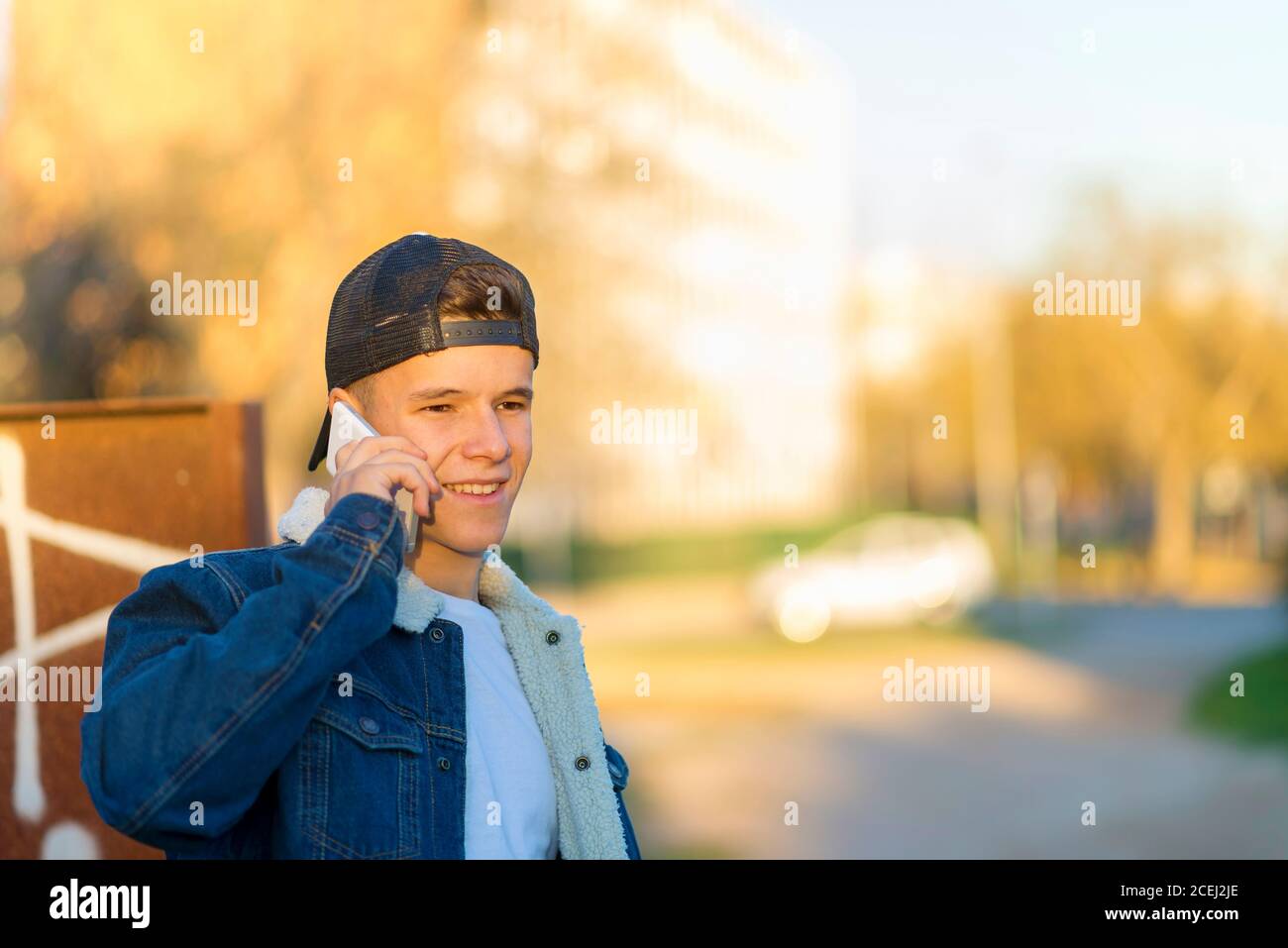 Porträt eines jungen Mannes im Freien trägt lässige Kleidung und Mit einem Smartphone Stockfoto