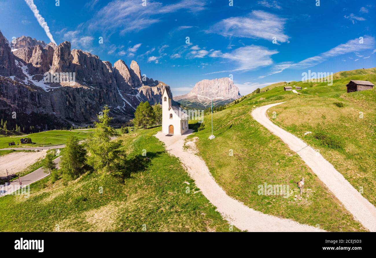 Schöne Luftpanorama zu Pfad zu kleinen weißen Kapelle San Maurizio und Dolomiti Berglandschaft im Hintergrund. Wolkenstein in Gröden Stockfoto