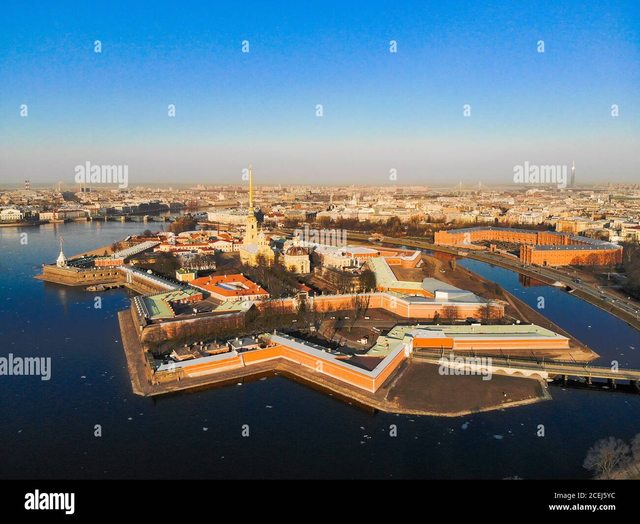 Schöne Luftaufnahme der Petropavlovsky Festung in sonnigen Frühlingstag. Goldene hohe Spitze der berühmten Peter-und-Paul-Kathedrale auf dem blauen Himmel Stockfoto
