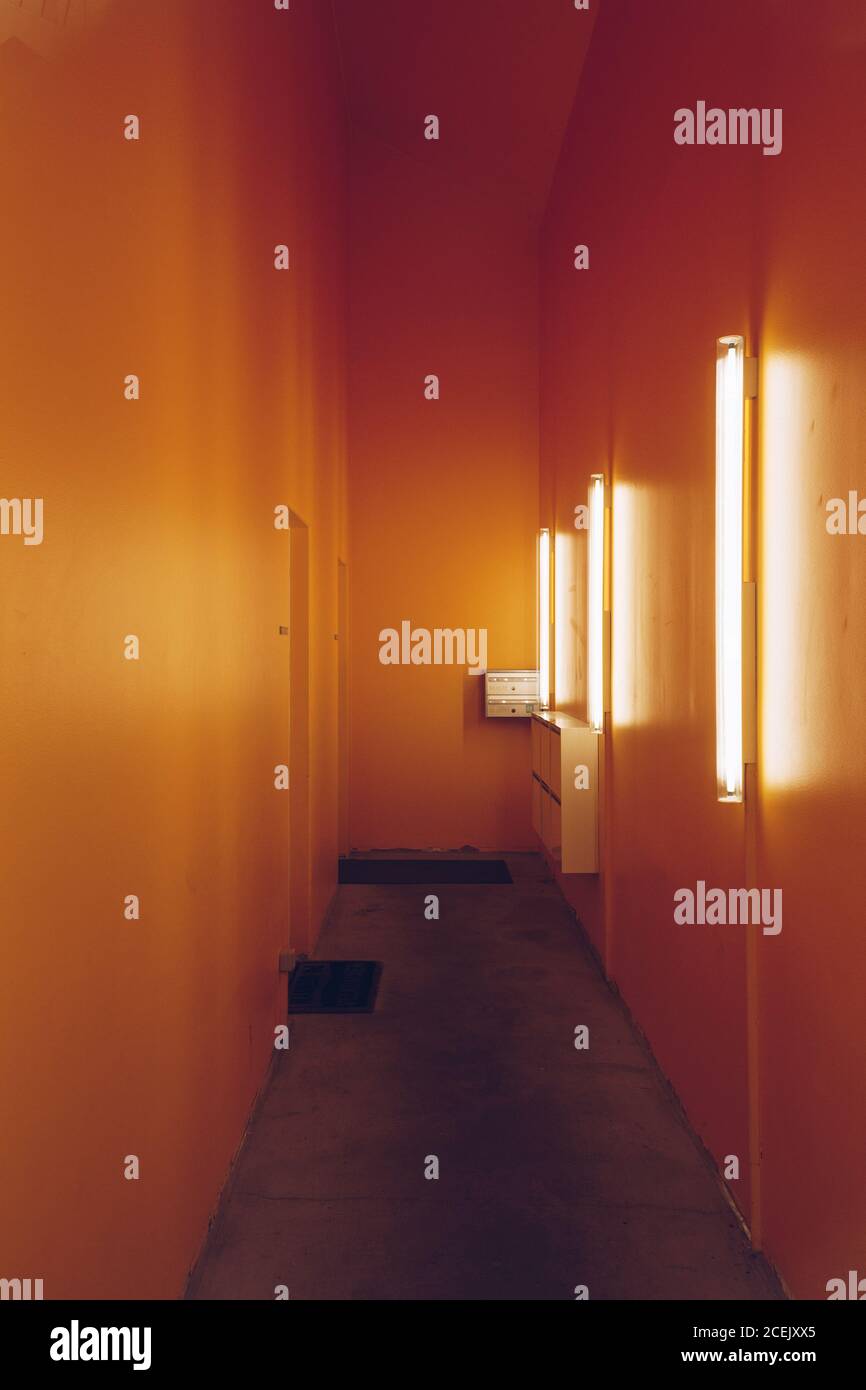 Innenaufnahme von schmal einfachen Halle Design mit elektrischen Lampen Und orangefarbene Wände Stockfoto
