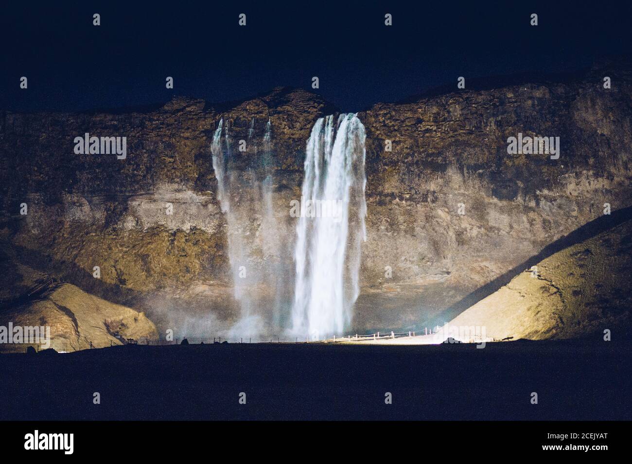 Hervorgehobene Wasserfallkaskade zwischen Felsen in der Dunkelheit in Island Stockfoto
