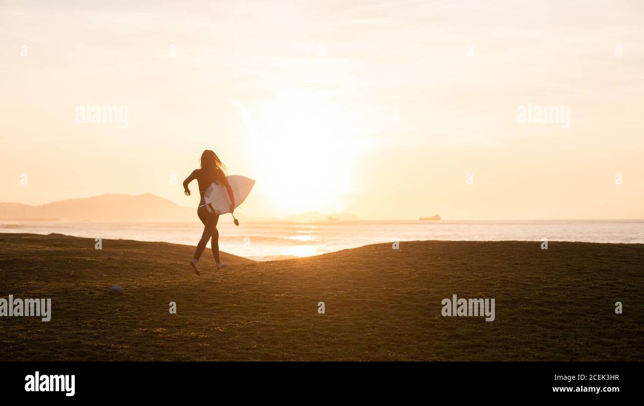 Anonyme Person mit Surfbrett an Land Stockfoto