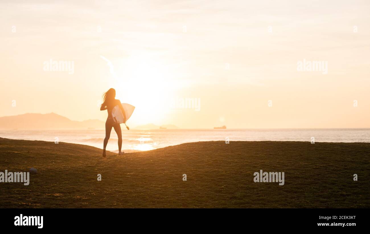 Anonyme Person mit Surfbrett an Land Stockfoto