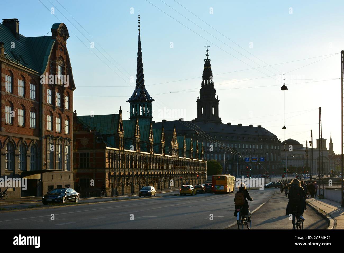 Kopenhagen, Dänemark - 17. Juni 2019: Die Menschen fahren mit dem Fahrrad vorbei am Schloss Christiansborg, Sitz des dänischen Parlaments in Kopenhagen. Stockfoto