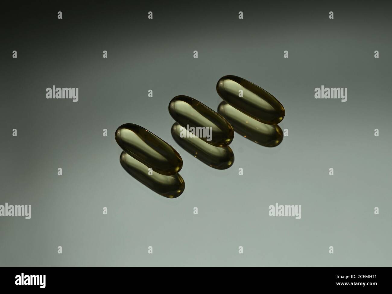 Fischöl Kapseln mit Omega 3 und Vitamin D auf dem Spiegel, glänzende Textur, gesunde Lebensweise, Diät-Konzept Stockfoto